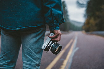 Man holding vintage camera on road
