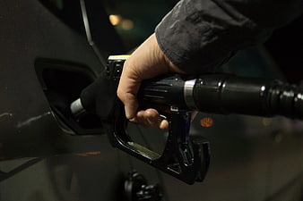 Hand Inserting Gas Pump Nozzle into Car Fuel Tank