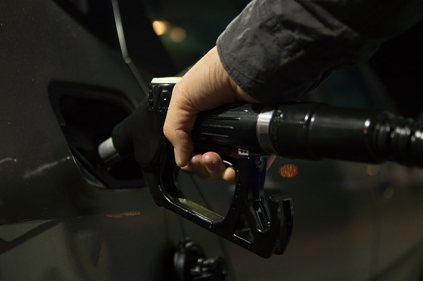 Hand Inserting Gas Pump Nozzle into Car Fuel Tank