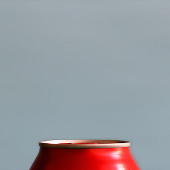 Close-up of red soda can top on blue background