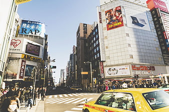 Busy Tokyo Street Scene with Yellow Taxi and Crowds