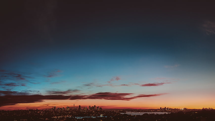Dramatic Sunset Skyline Over City with Clouds