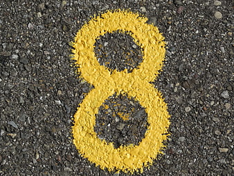 Yellow Number Eight Painted On Rough Asphalt Road Surface