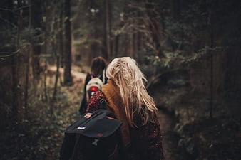 Two Women Hiking Through Autumn Forest Trail