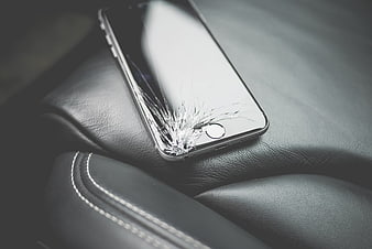 Cracked Smartphone Screen on Black Leather Surface