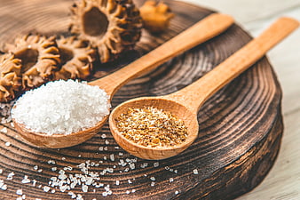 Wooden spoons with salt and spices on rustic board