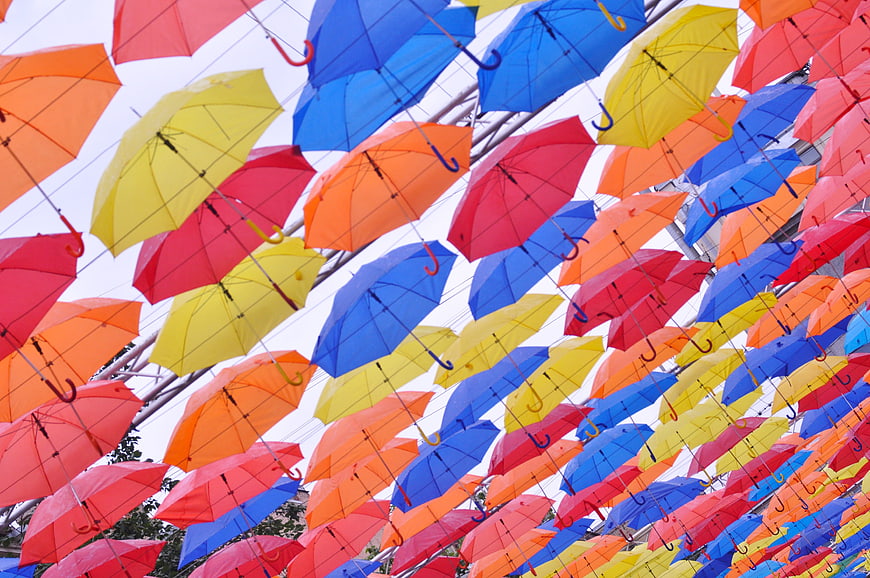 Colorful umbrellas hanging overhead in a vibrant street art installation