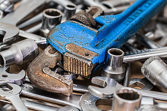 Close-up of worn blue pipe wrench and metal tools