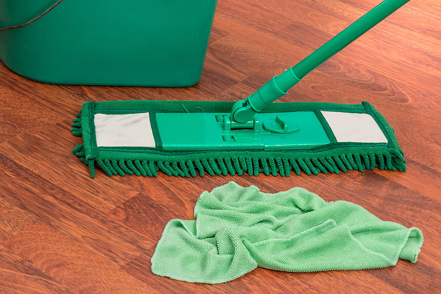 Green Mop and Bucket on Wooden Floor with Cloth