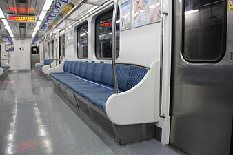 Empty blue seats inside a modern Korean subway train car