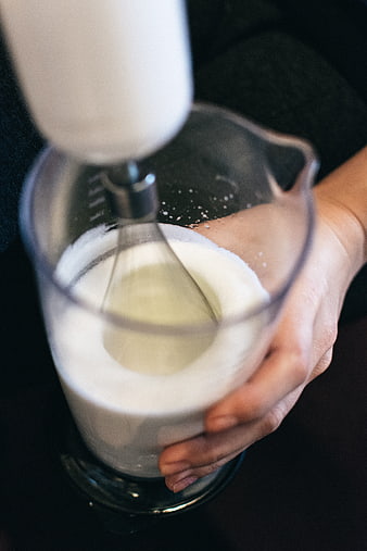 Close-up of hands whipping batter in a glass bowl