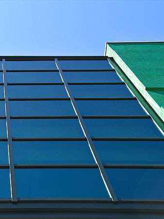 Modern Glass Building Facade with Blue Sky Background