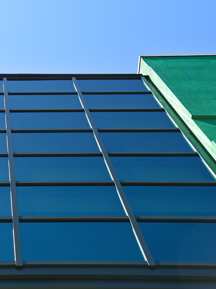 Modern Glass Building Facade with Blue Sky Background