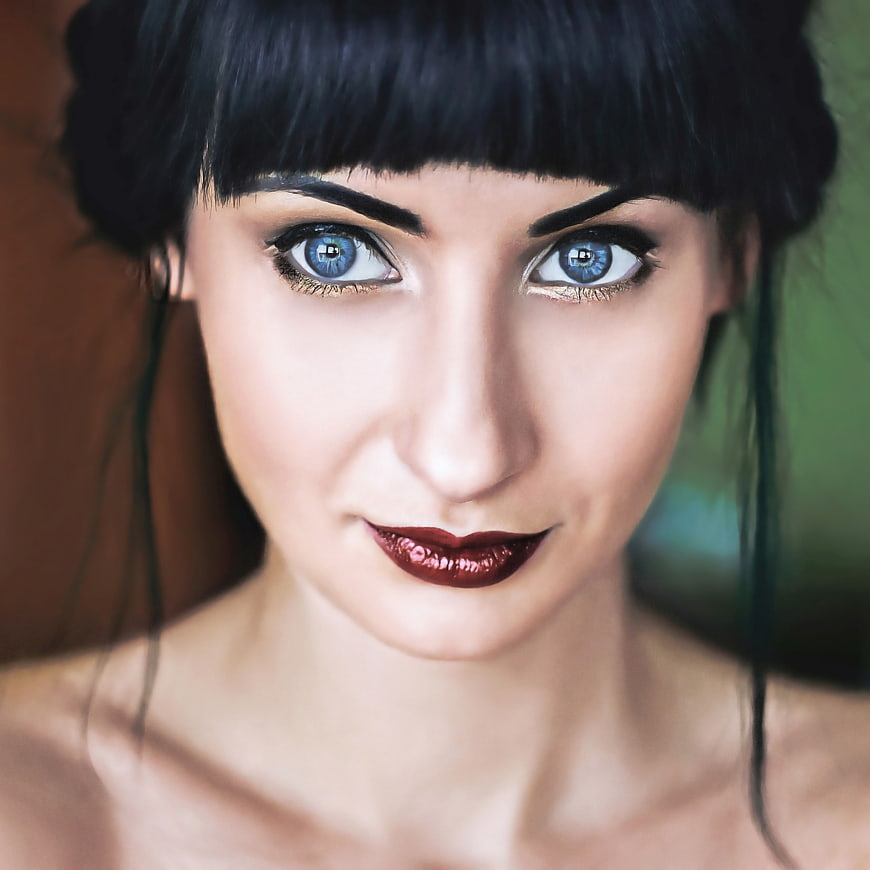 Close-up portrait of woman with striking blue eyes and dark hair