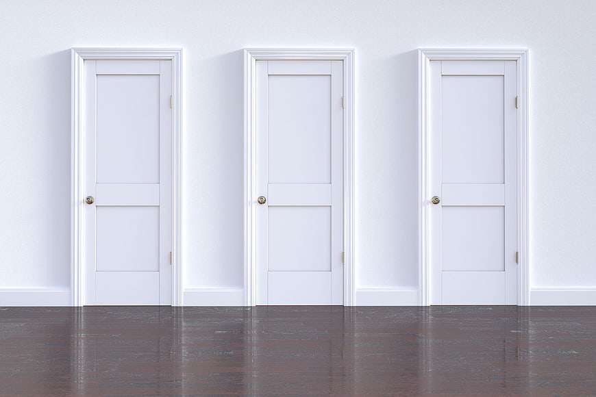 Three White Interior Doors On Wall With Dark Wood Floor