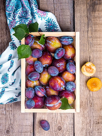 Fresh Plums in Wooden Crate on Rustic Table