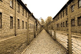 Sepia toned historical concentration camp barracks with barbed wire fence