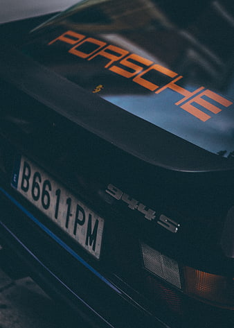 Close-up of black Porsche 944 S rear with orange decal