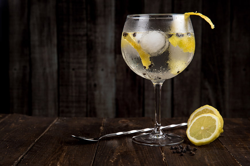 Refreshing Gin and Tonic Cocktail with Lemon and Peppercorns