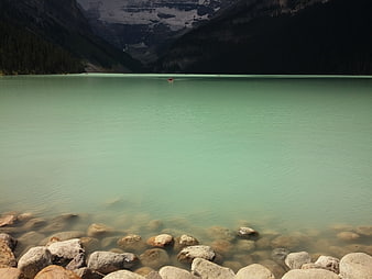 Turquoise glacial lake with rocky shore and mountains