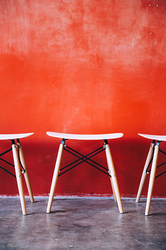 Modern White Stools Against Vibrant Red Textured Wall
