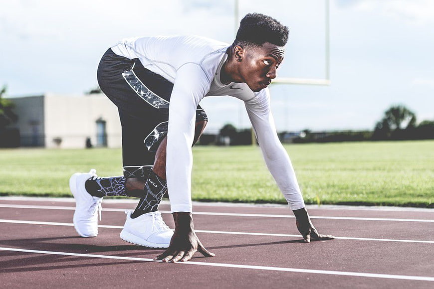 Athletic Man in Starting Position on Running Track