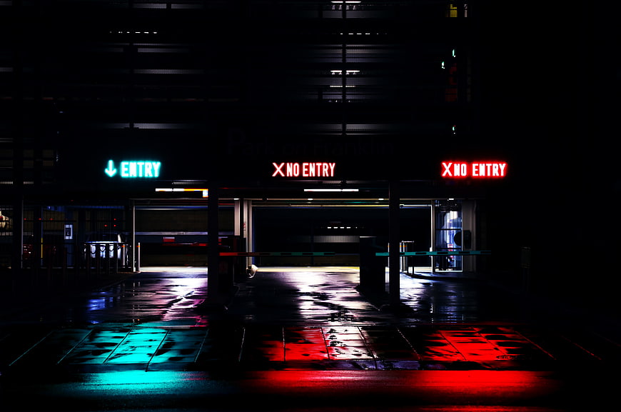 Neon Entry and No Entry Signs in Dark Parking Garage