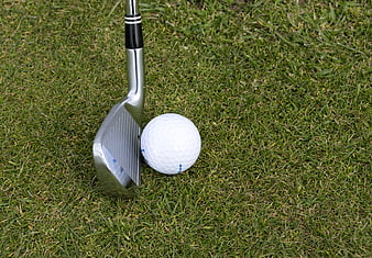 Golf Iron and White Ball on Green Grass