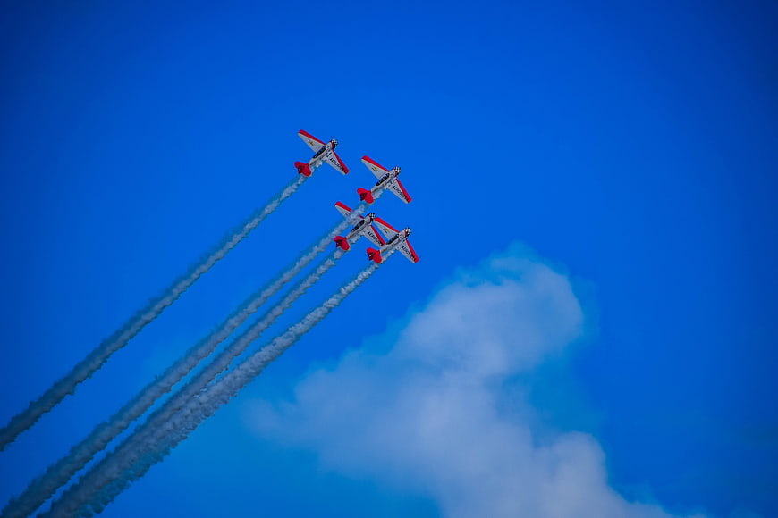 Four Red and White Aerobatic Planes Flying in Formation
