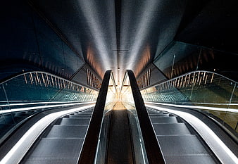Symmetrical view of modern escalators in a dark architectural interior