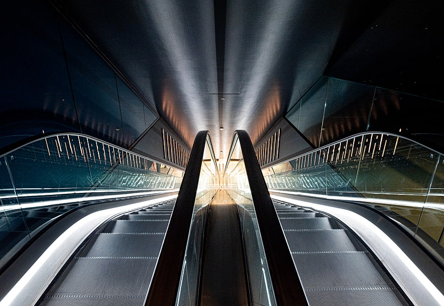 Symmetrical view of modern escalators in a dark architectural interior
