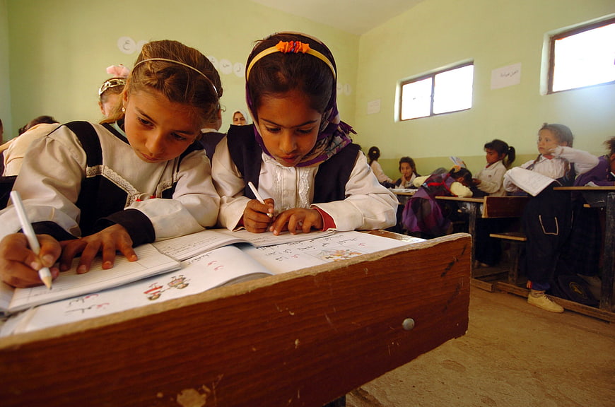 Two young girls studying together in a classroom