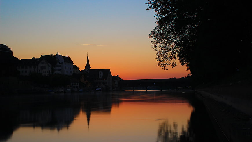 Silhouette of European Town and Church at Sunset Over River