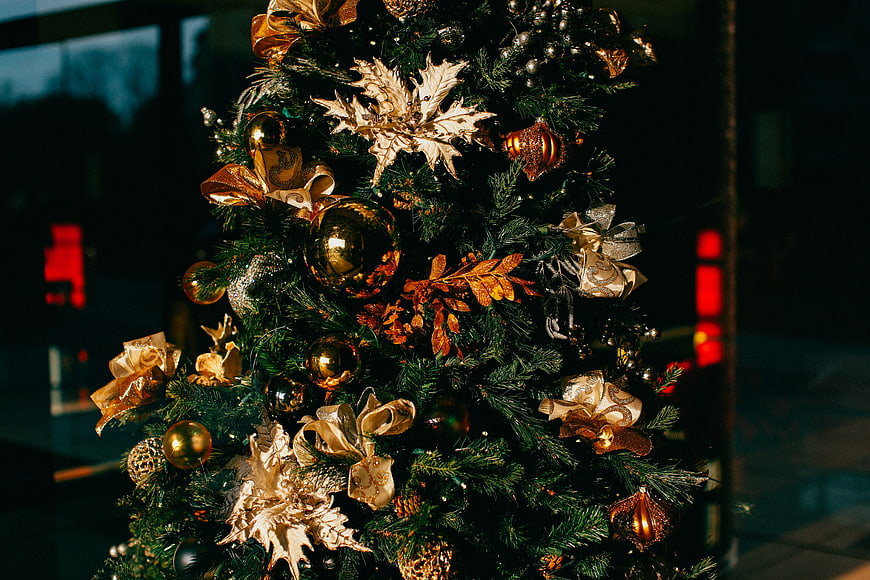 Close-up of Christmas tree with gold ornaments and festive decorations