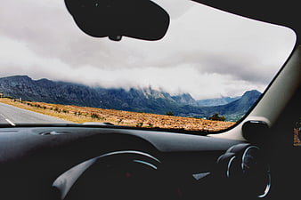 View from car dashboard driving through mountain landscape