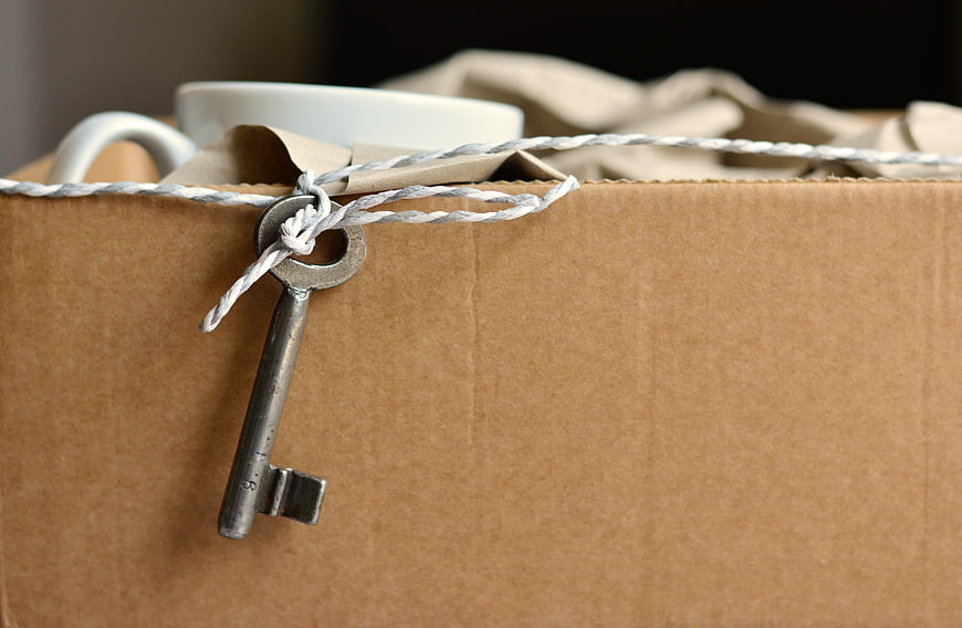 Vintage Key Tied to Moving Box with Household Items