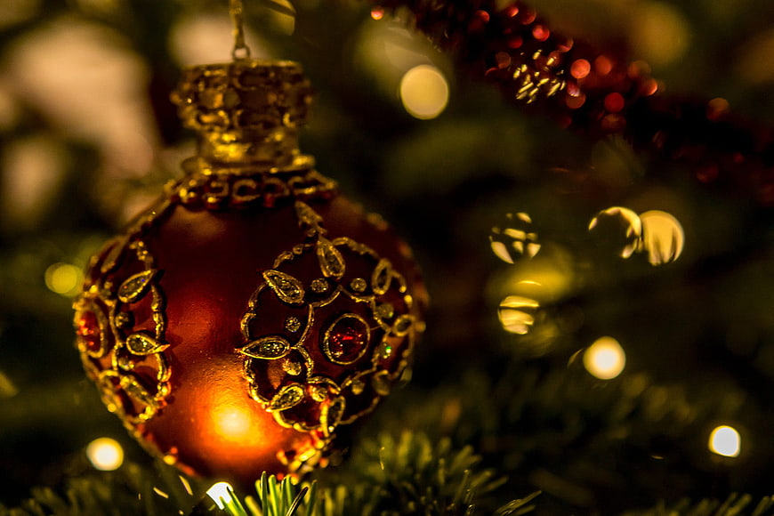 Close-up of ornate red and gold Christmas bauble on tree