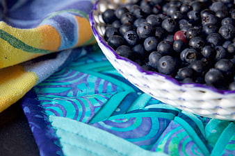 Fresh Blueberries in White Bowl on Colorful Fabric