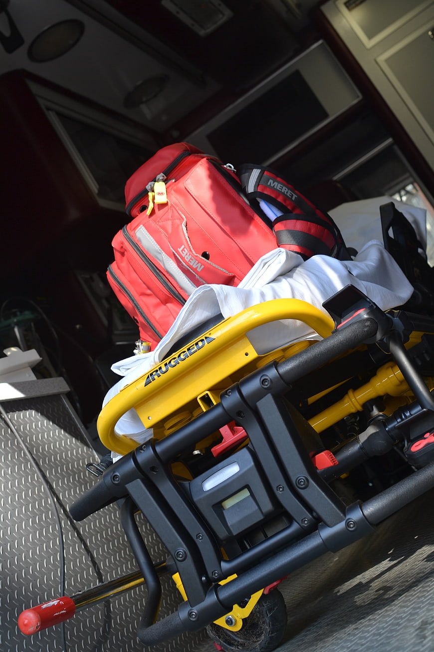 Red medical bag on yellow stretcher in ambulance
