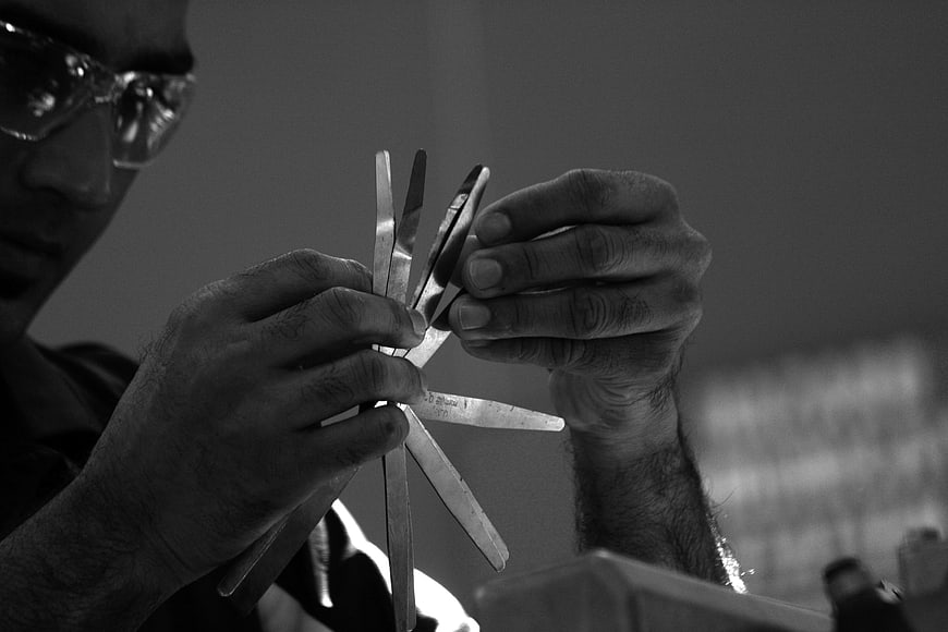 Close-up of mechanic hands holding metal tools in workshop