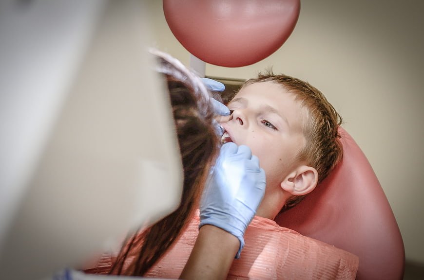 Young boy receiving dental treatment in a clinic chair