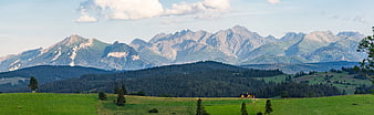 Panoramic View of Green Hills and Majestic Mountain Peaks