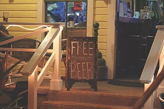 Chalkboard sign advertising free beer on porch steps