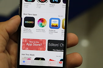 Hand holding smartphone displaying App Store interface