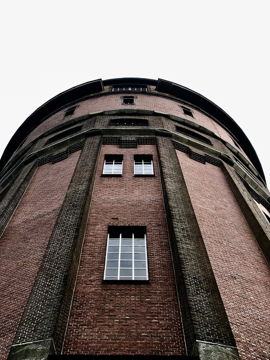 Low angle view of red brick water tower architecture