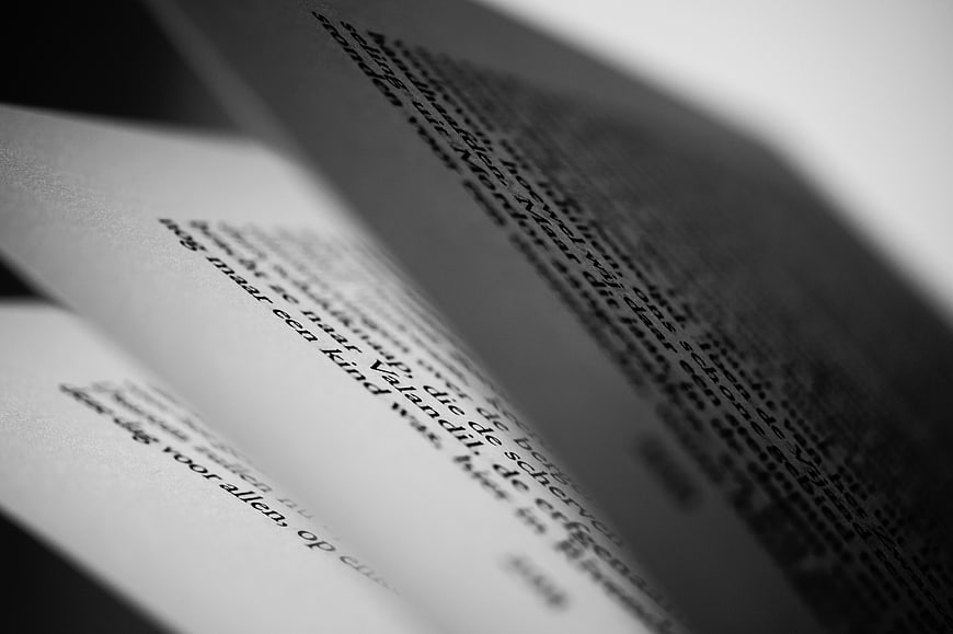 Close-up of open book pages with Dutch text in black and white