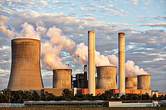 Power plant cooling towers emitting steam at sunset
