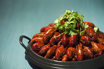 Spicy Boiled Crayfish in Black Bowl with Cilantro Garnish