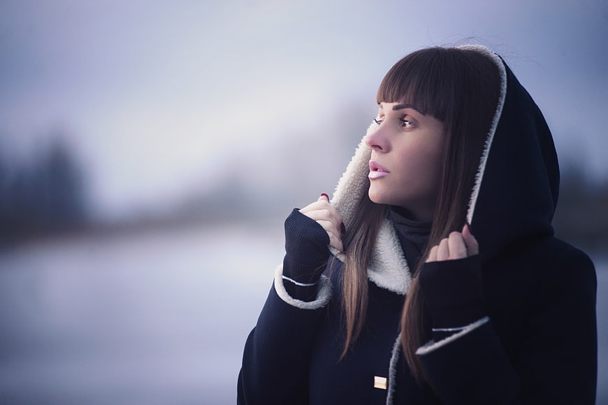 Woman in Winter Hoodie Looking Away in Cold Landscape
