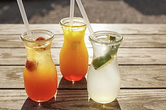 Three Refreshing Summer Lemonades In Glass Bottles On Wooden Table